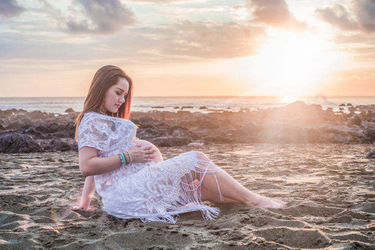 Femme enceinte posant au coucher du soleil